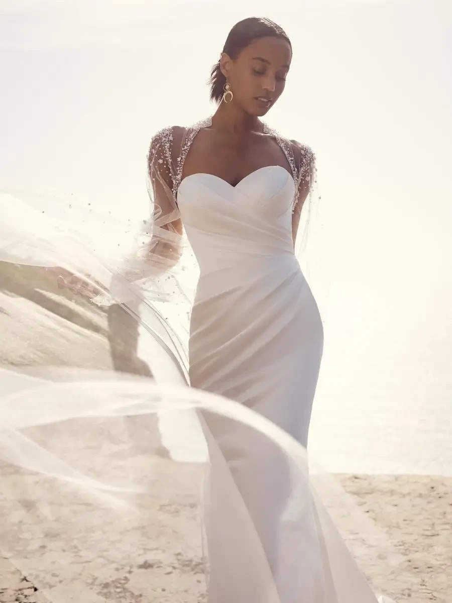 model is wearing a strapless fit and flare ruched bridal gown